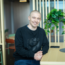Hymyilevä Oskari Saarinen istumassa pöydän ääressä