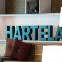 Hartelan Ilmalan toimipisteen pieni atrium, jossa Hartelan logo puukirjaimina