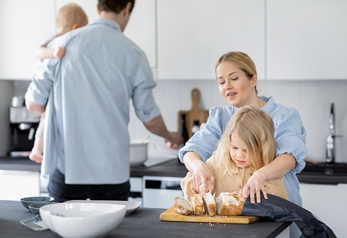 Perhe valmistaa ruokaa skandinaavisessa keittiössä.