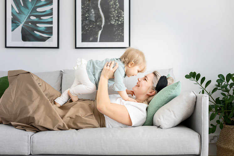 Äiti leikkii lapsen kanssa Hartelan rakentamassa kodissa