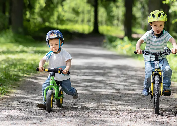 Lapset pyöräilevät luontopolulla kesäisessä säässä.