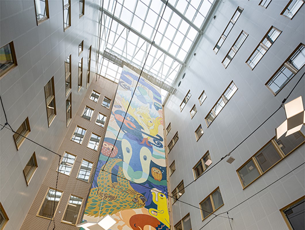Hartelan rakentaman T3 sairaalan aulassa kohoaa värikäs seinämuraali kohti avointa ikkunakattoa