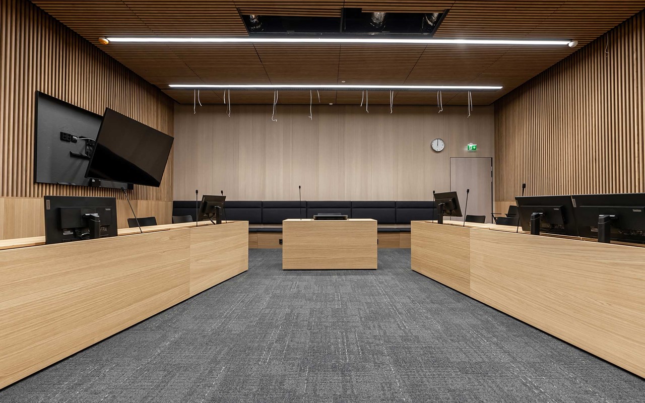 Oulun oikeustalon salissa pintamateriaaleina on käytetty runsaasti puuta.